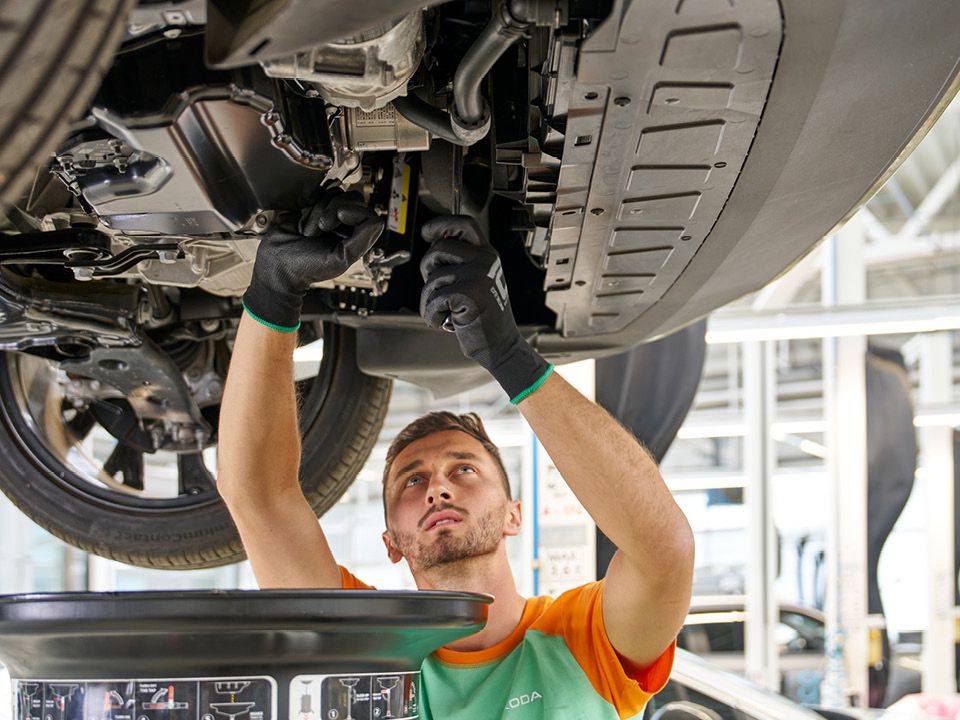 Ein Škoda Mechaniker beim Ölwechsel bei einem Škoda.