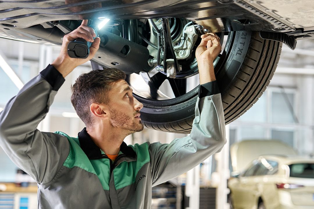 Ein Škoda Mechaniker repariert das Radlager eines Škoda.