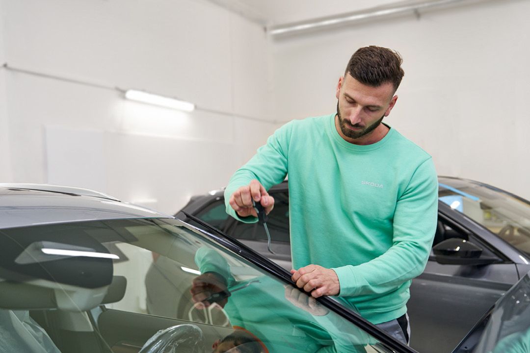 Ein Škoda Mechaniker repariert eine Windschutzscheibe.