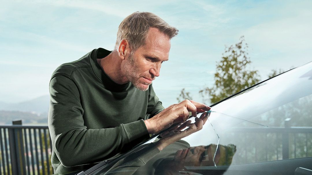 Ein Škoda Techniker kontrolliert einen Steinschlagschaden an einer Windschutzscheibe.