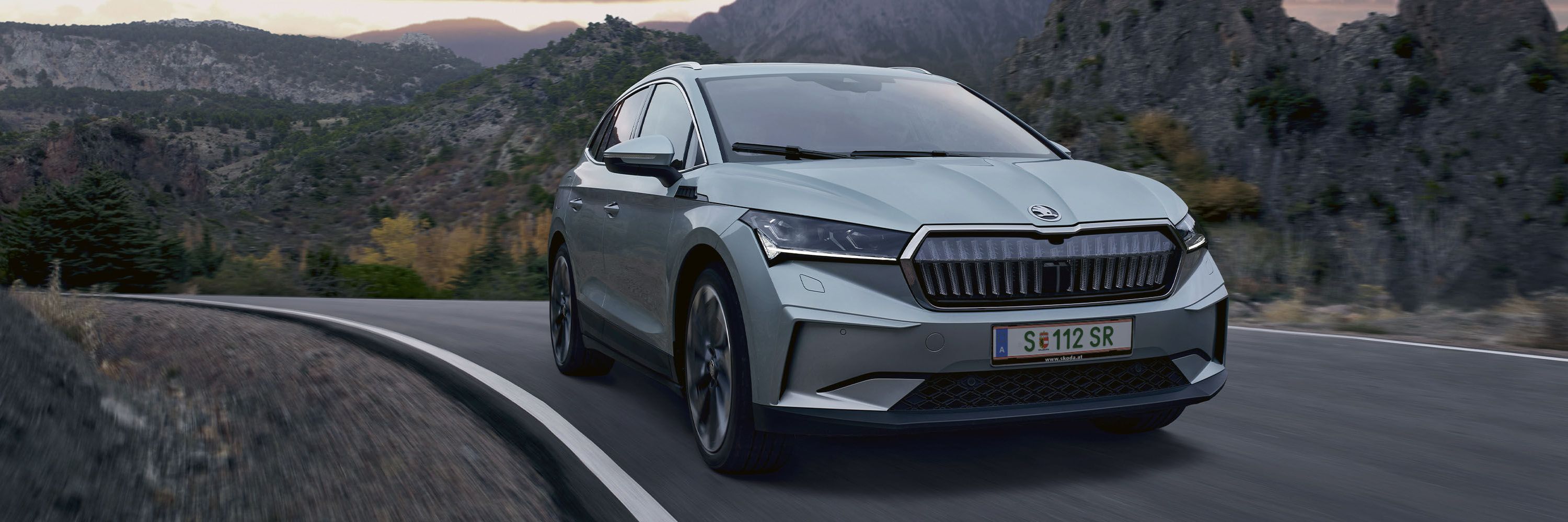 Ein Škoda Enyaq in voller Fahrt auf einer Bergstraße.