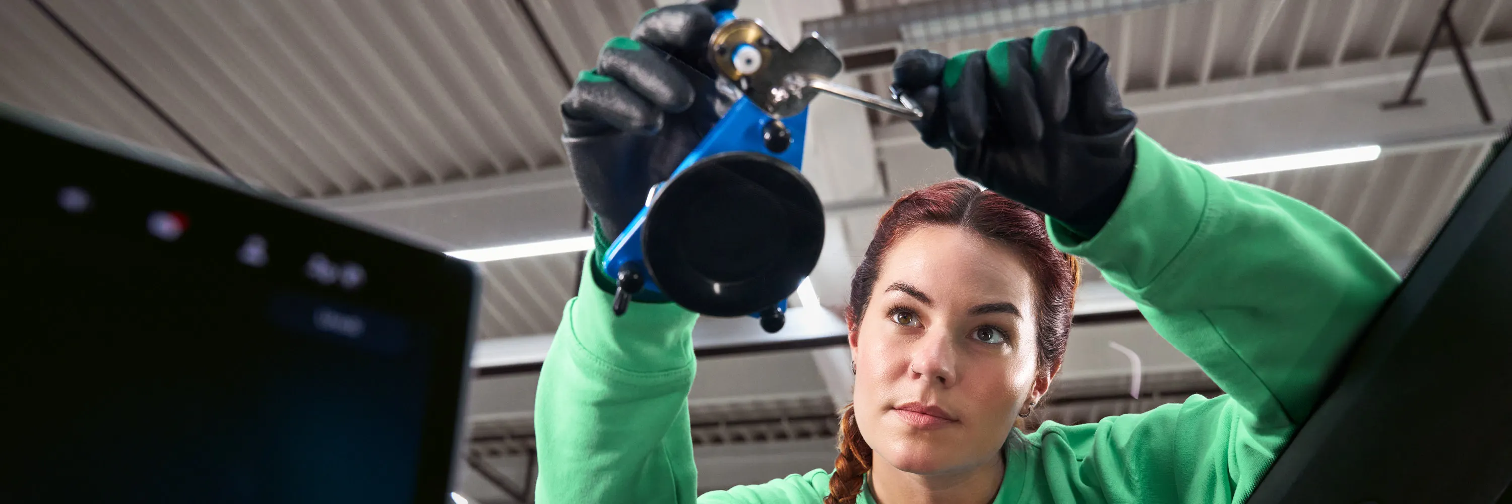 Eine Škoda Technikerin befestigt einen Saugnapf an einer Windschutzscheibe.