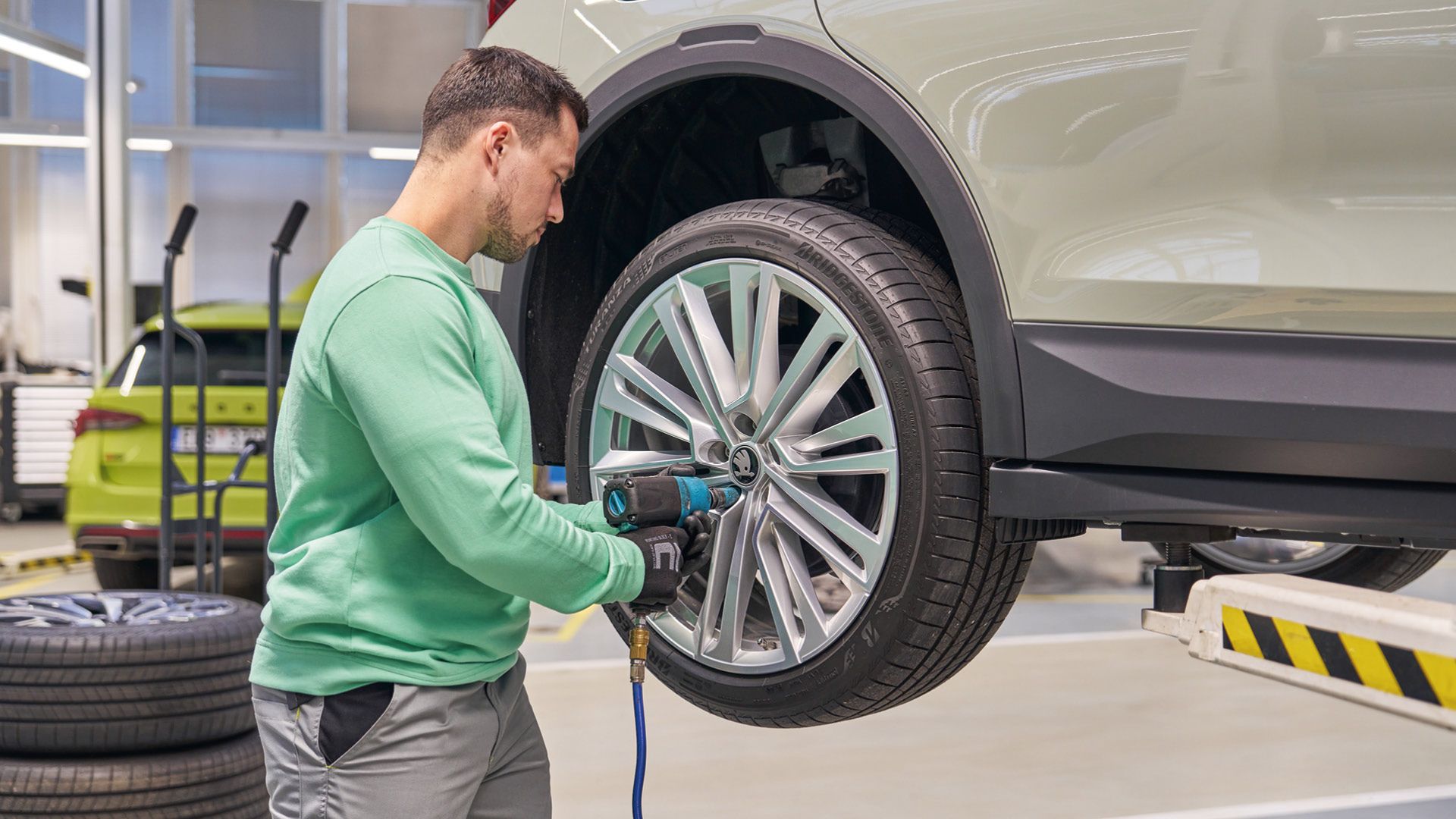 Ein Škoda Mechaniker beim Räderwechsel.