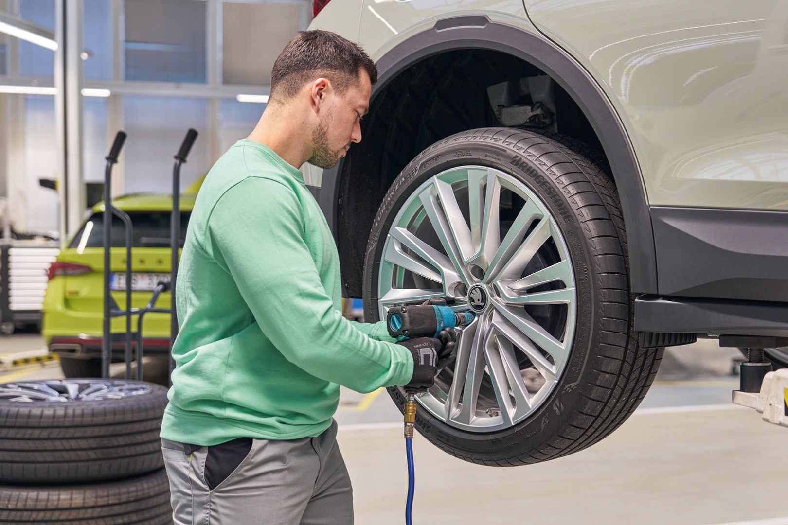 Ein Škoda Mechaniker beim Räderwechsel.