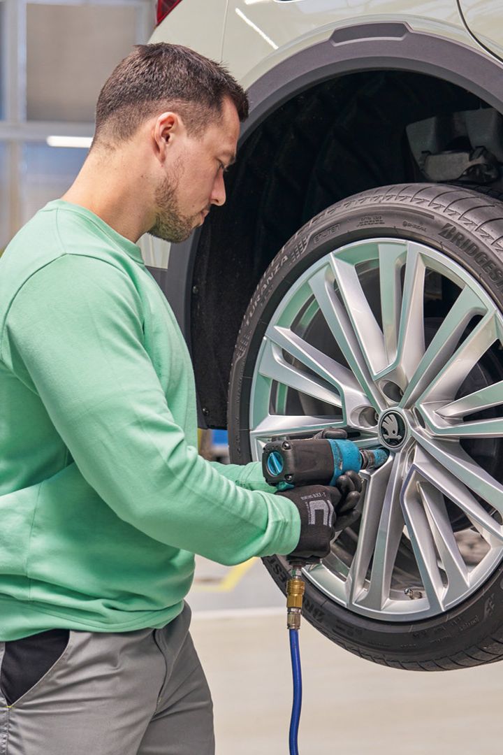 Ein Škoda Mechaniker beim Räderwechsel.