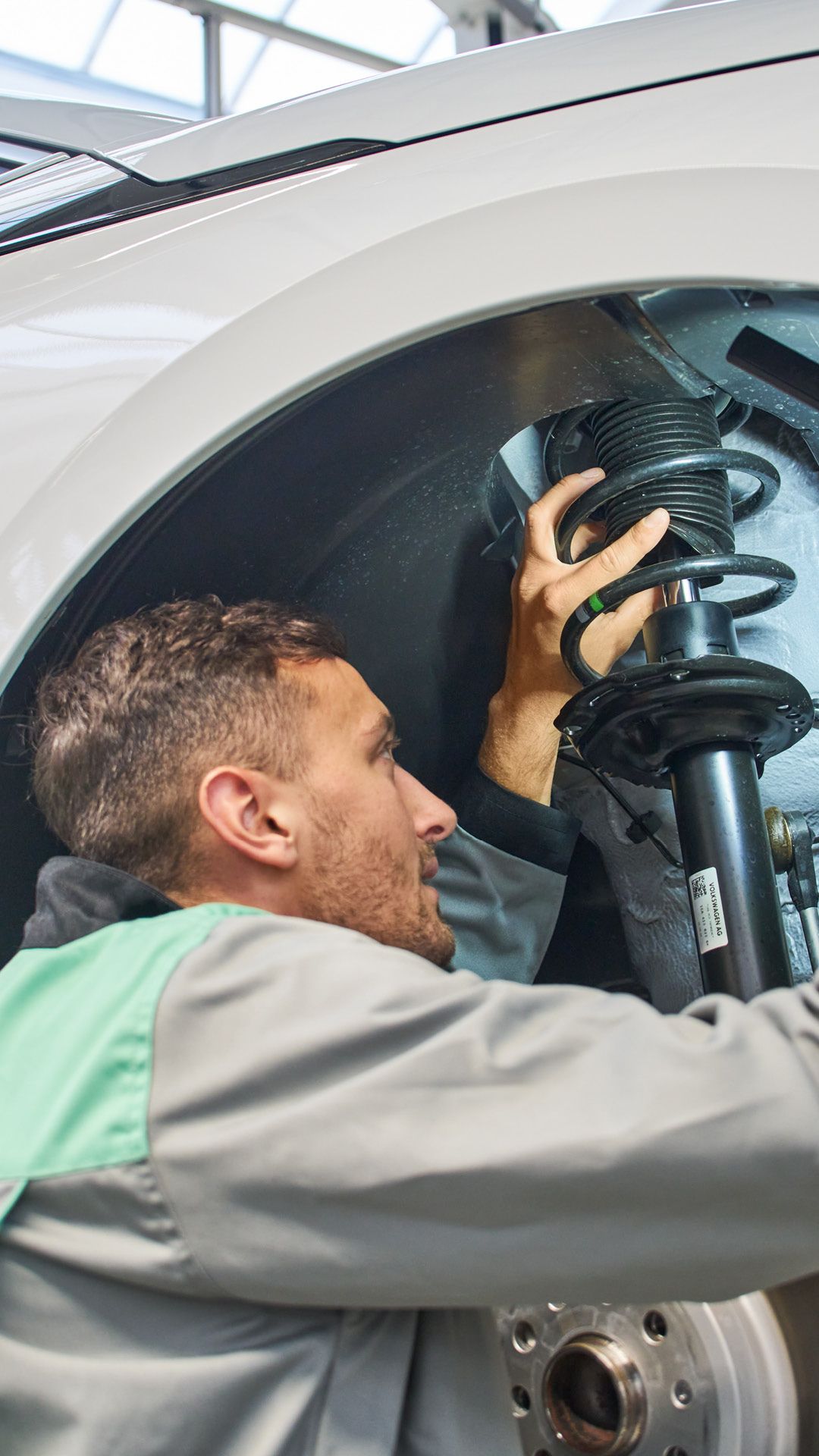 Ein Škoda  Mechaniker kontrolliert den Stoßdämpfer eines Škoda.