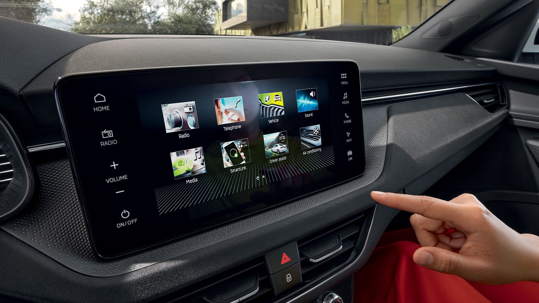 Eine Person bedient das Touchscreen-Infotainmentdisplay im Škoda Kamiq vom Beifahrersitz aus