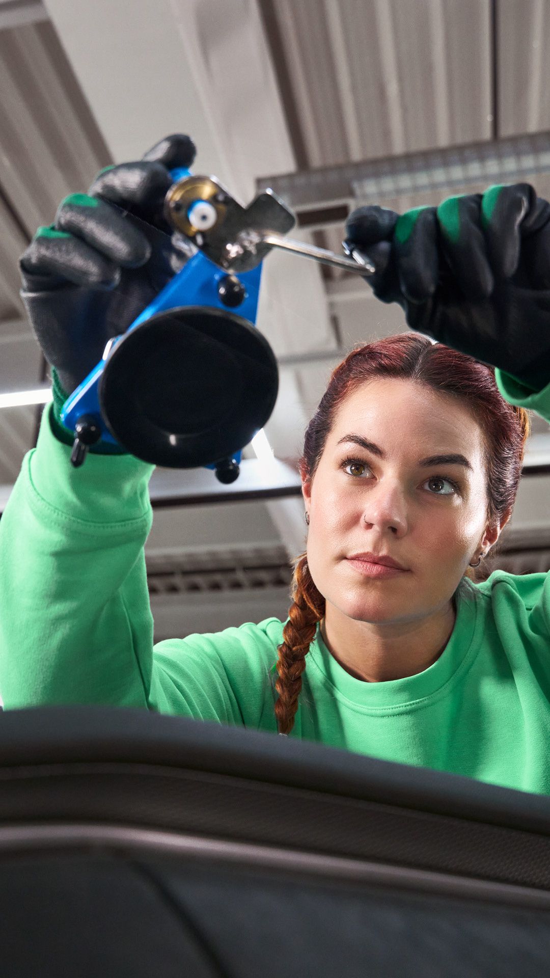 Eine Škoda Technikerin befestigt einen Saugnapf an einer Windschutzscheibe.