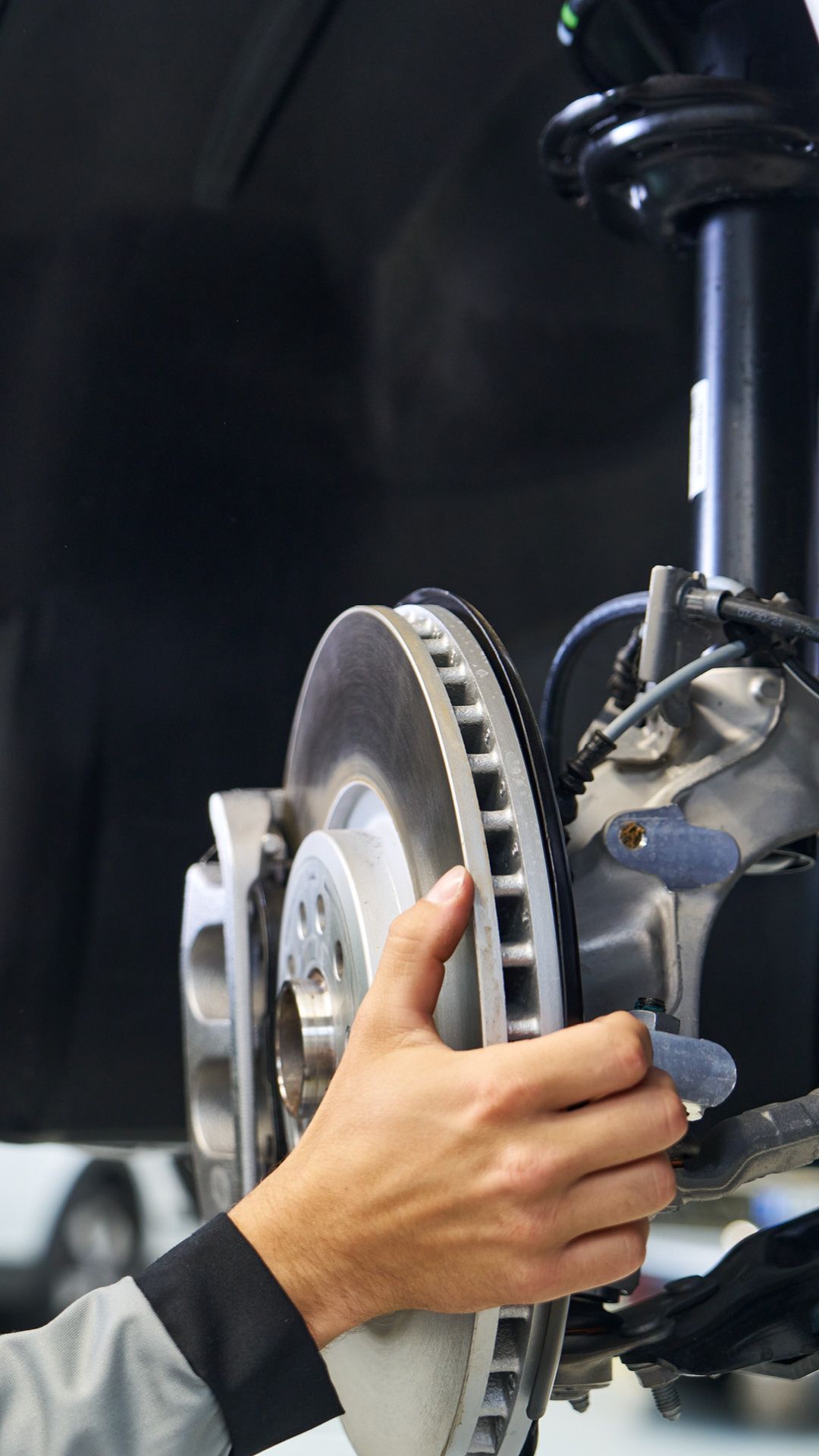 Ein Škoda Mechaniker beim Bremsenwechsel. 