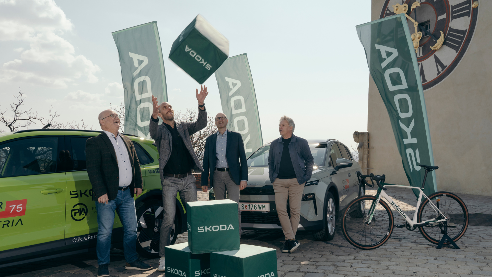 zwei Škoda Elroq vor Uhrturm in Graz mit Škoda Team und Tour of Austria Team