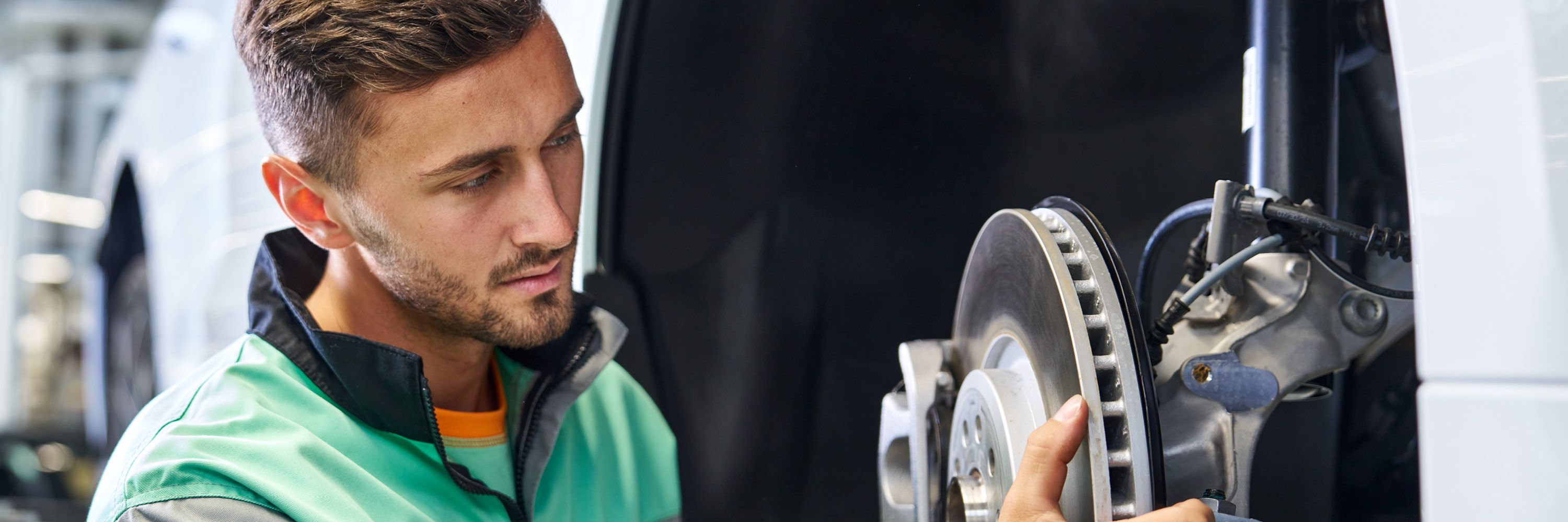 Ein Škoda Mechaniker beim Bremsenwechsel. 