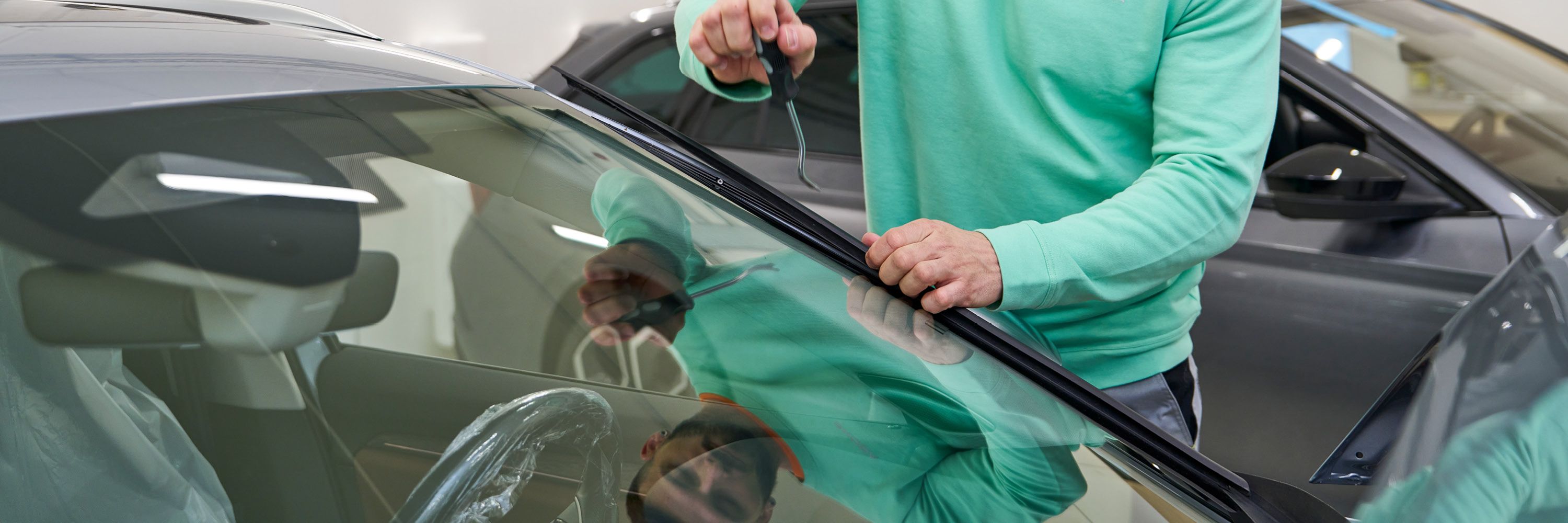 Ein Škoda Mechaniker repariert eine Windschutzscheibe.