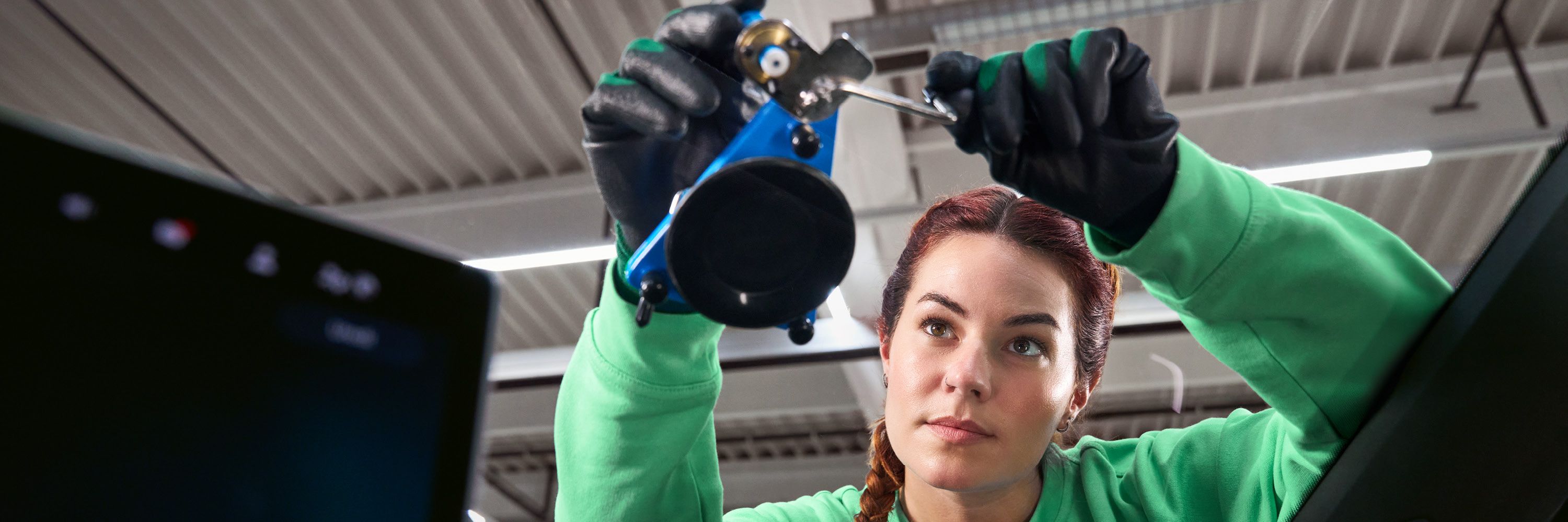 Eine Škoda Technikerin befestigt einen Saugnapf an einer Windschutzscheibe.