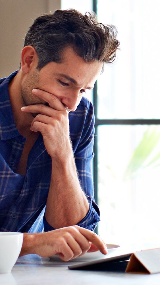 Mann blickt auf sein Tablet