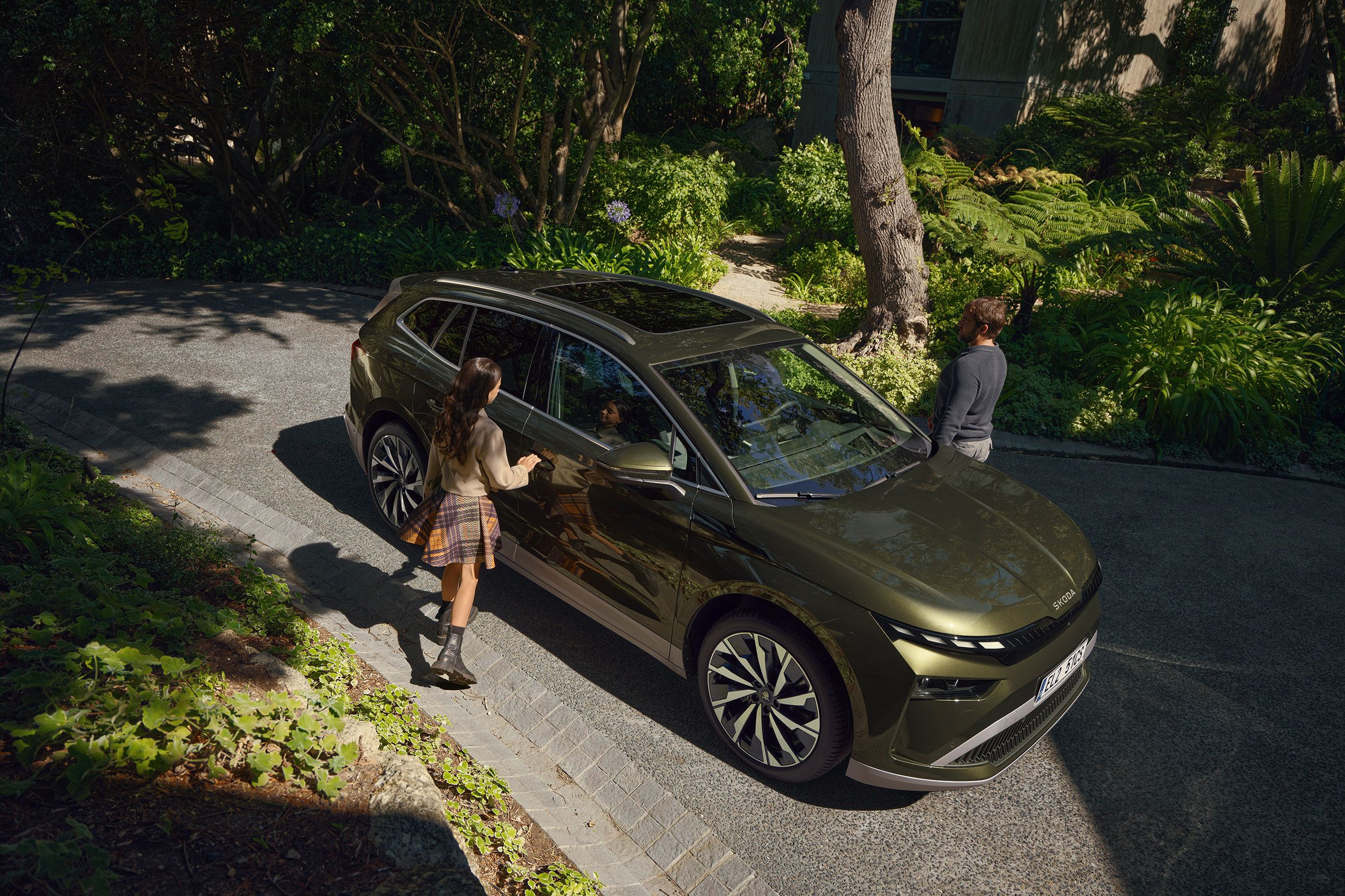 Zwei Personen stehen neben einem Škoda Enyaq