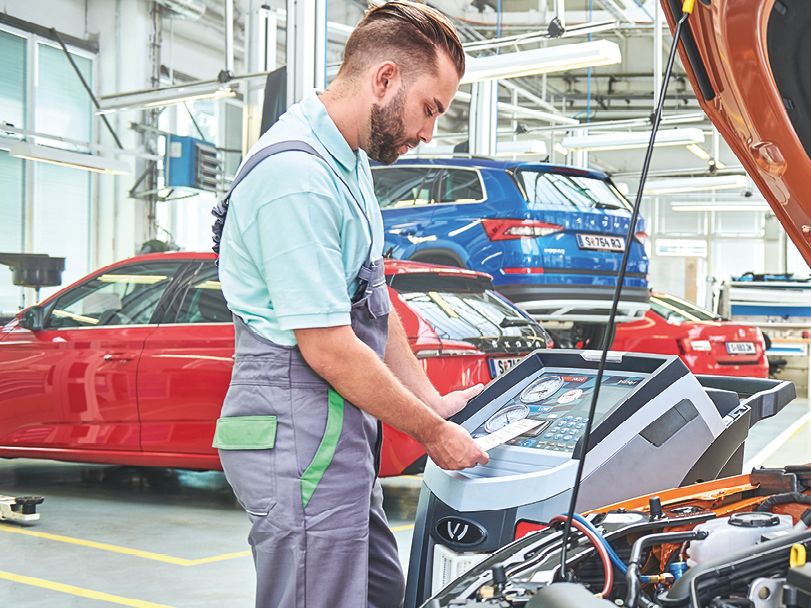 Ein Škoda Mechaniker in der Werkstatt bedient ein elektronisches Prüfgerät