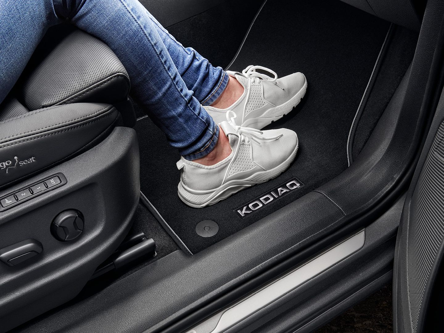 Person in einem Škoda Kodiaq mit Fokus auf die Fußmatte