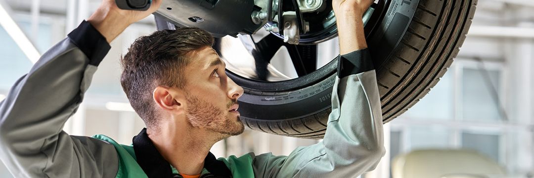 Ein Škoda Mechaniker repariert das Radlager eines Škoda.