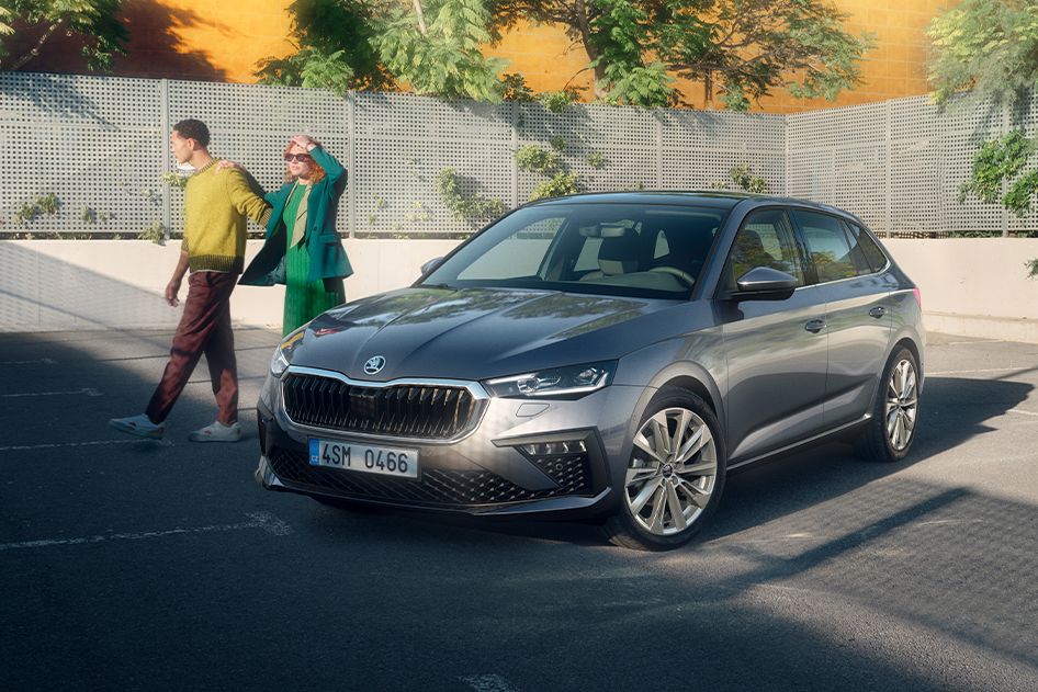 Zwei Personen stehen neben einem grauen Škoda Scala