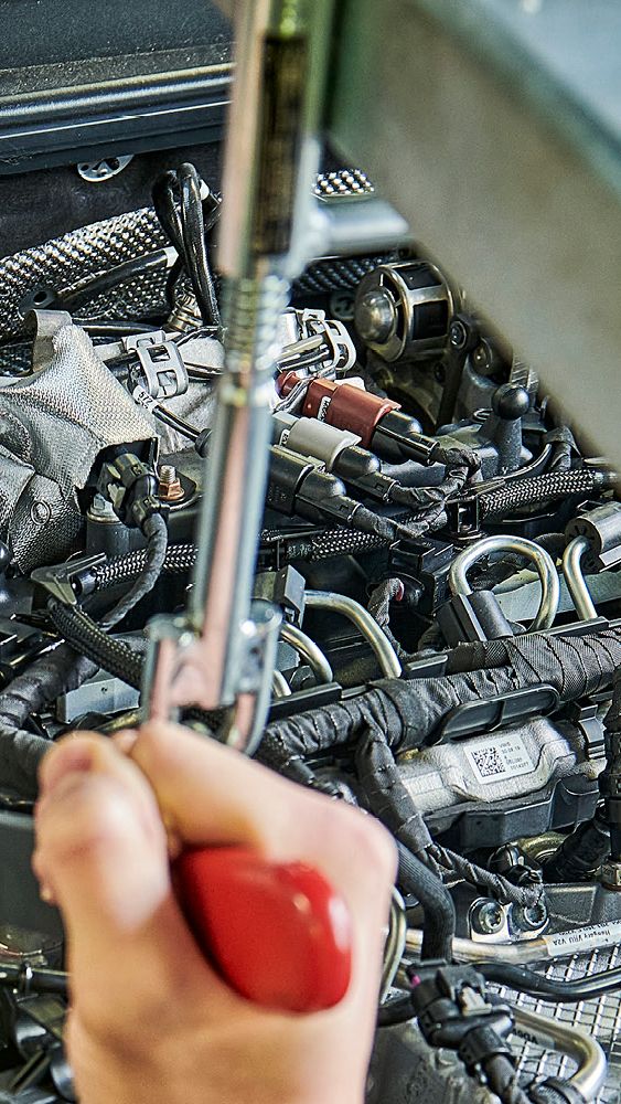 Ein Škoda Mechaniker wechselt den Zahnriemen bei einem Škoda