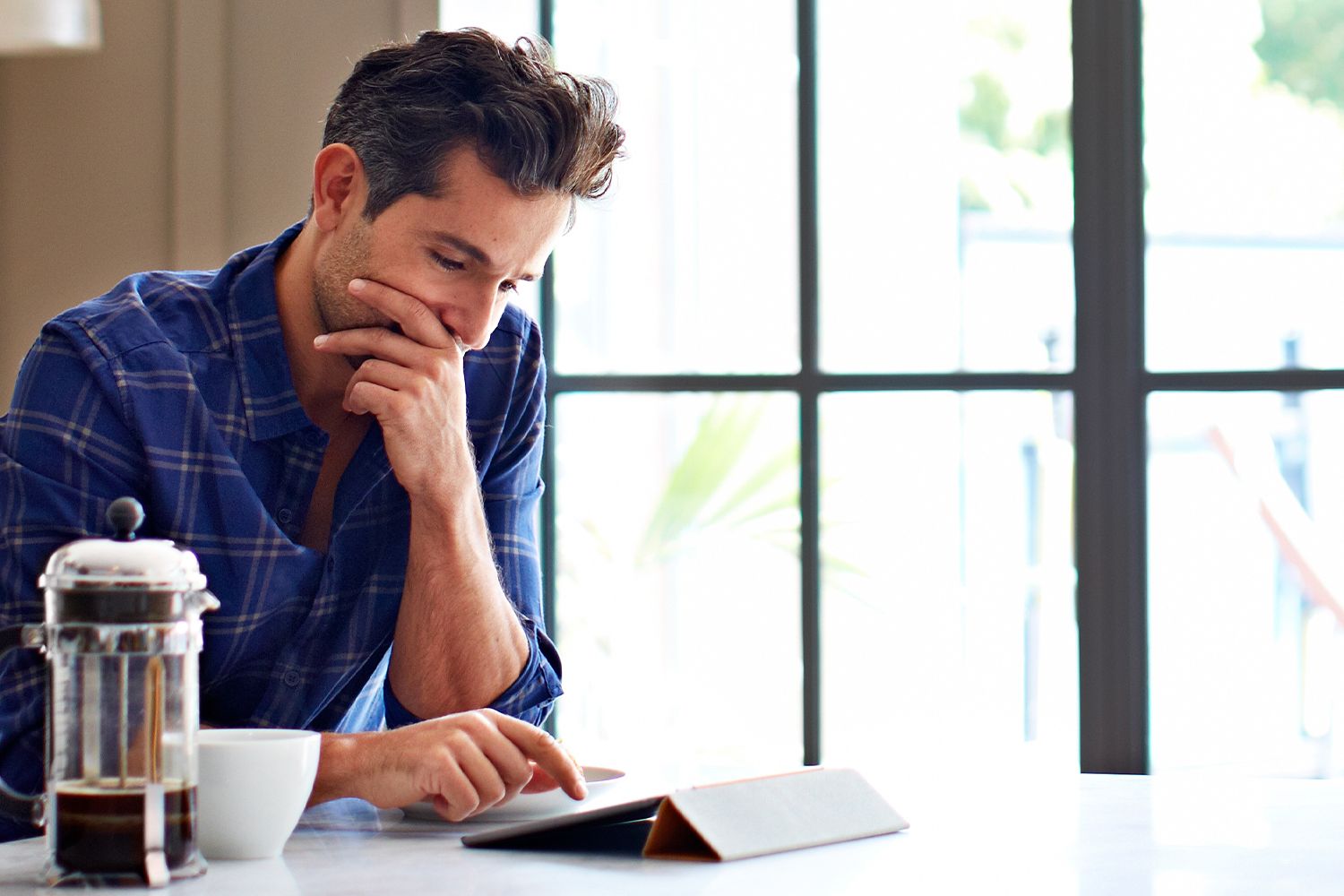 Mann blickt auf sein Tablet